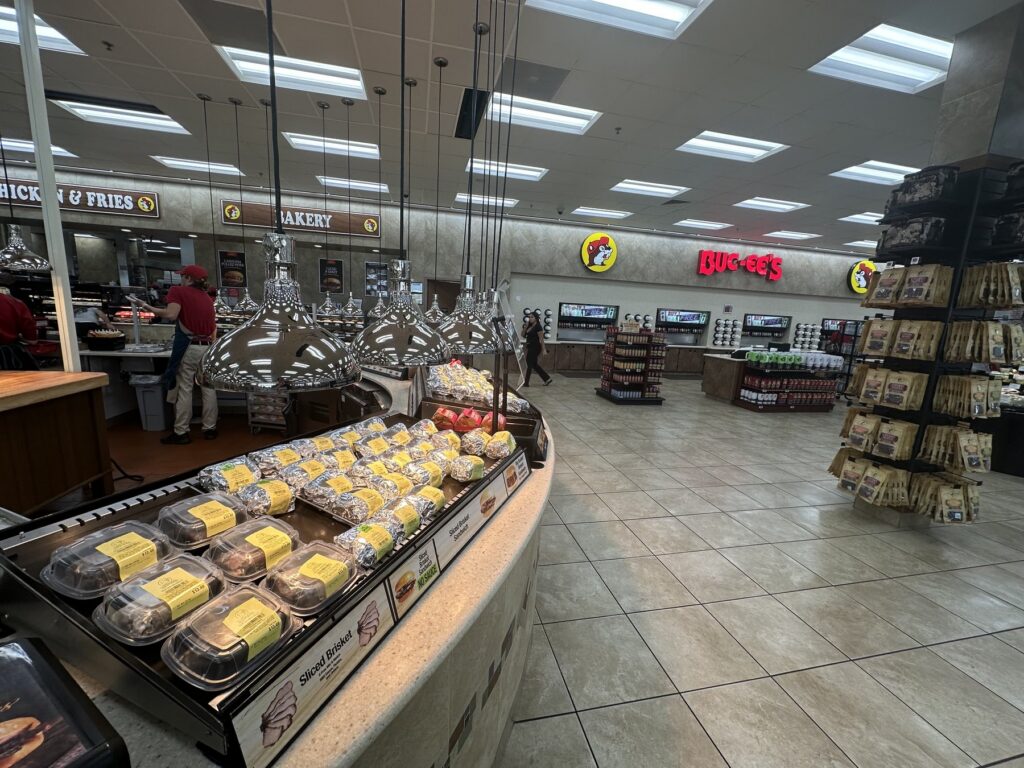 Prepared food counter with wrapped sandwiches inside Buc-ee's in Denton