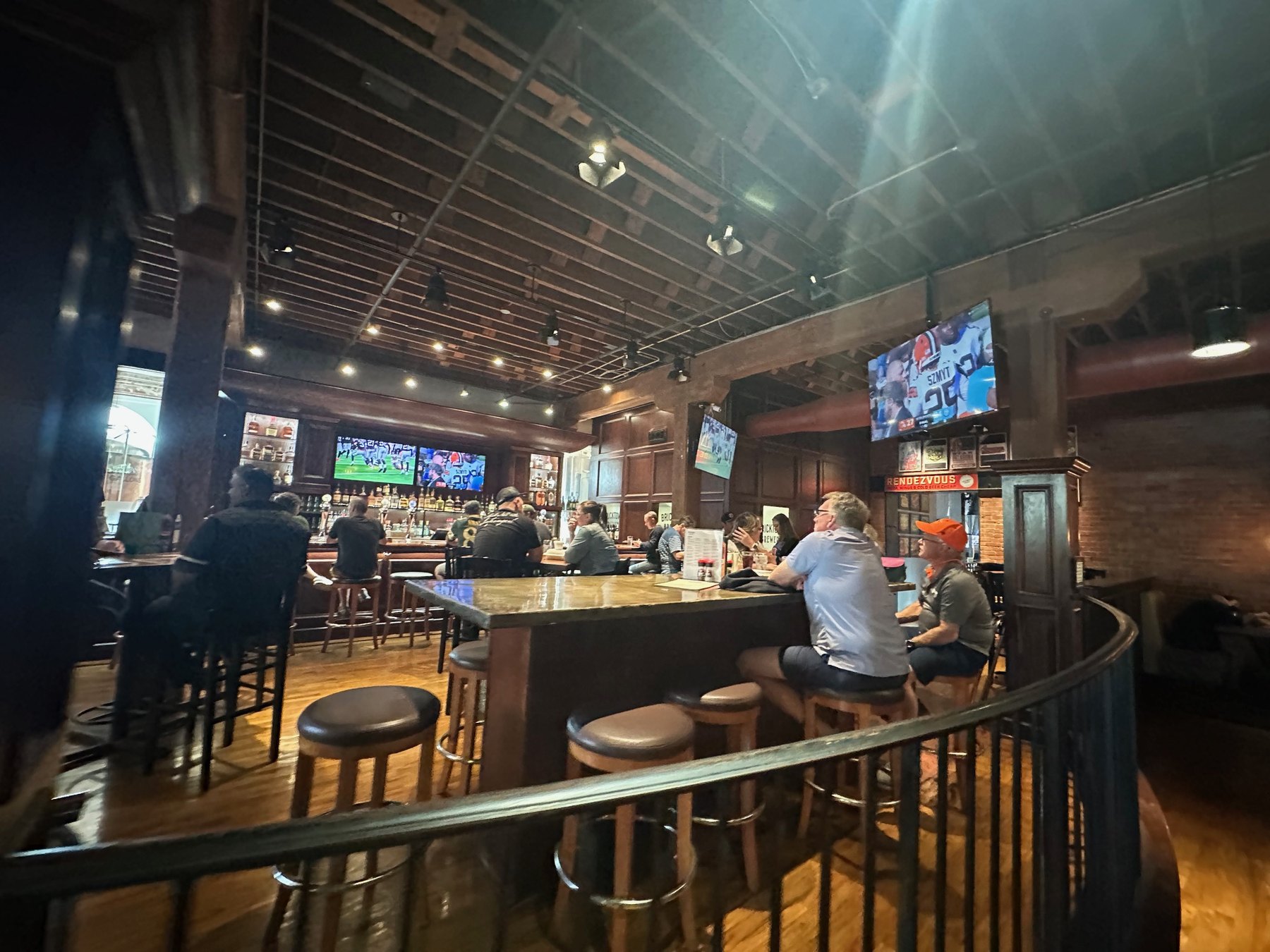 Bar area at Bricktown Brewery with sports on televisions and guests seated at high-top tables.