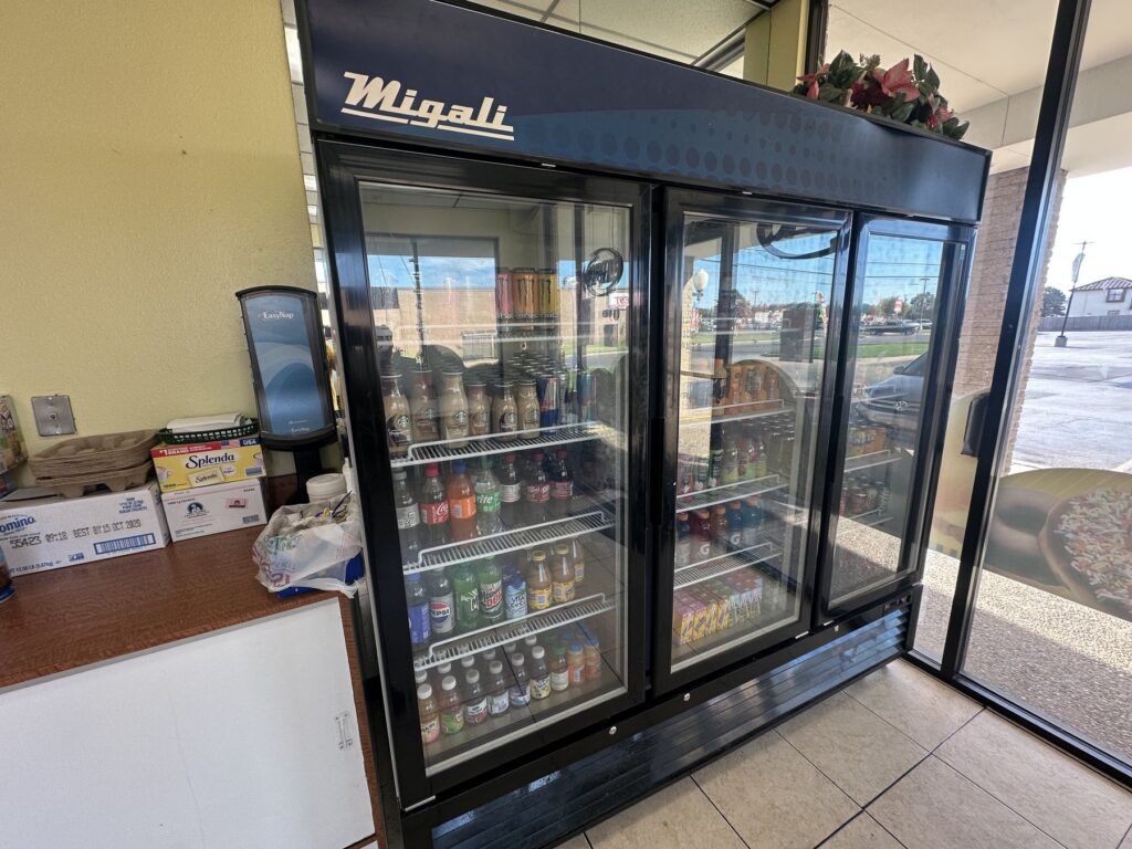 Refrigerated drink case with bottled beverages inside an Oklahoma donut shop.