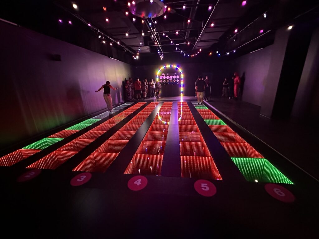 Red and green LED floor panels in a bridge-style Squid Game challenge room at Netflix House Dallas.