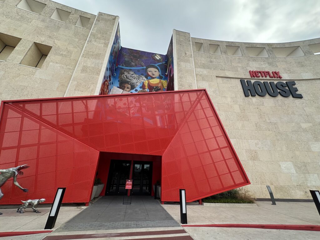 Exterior entrance of Netflix House Dallas with a red geometric canopy and Netflix House sign.