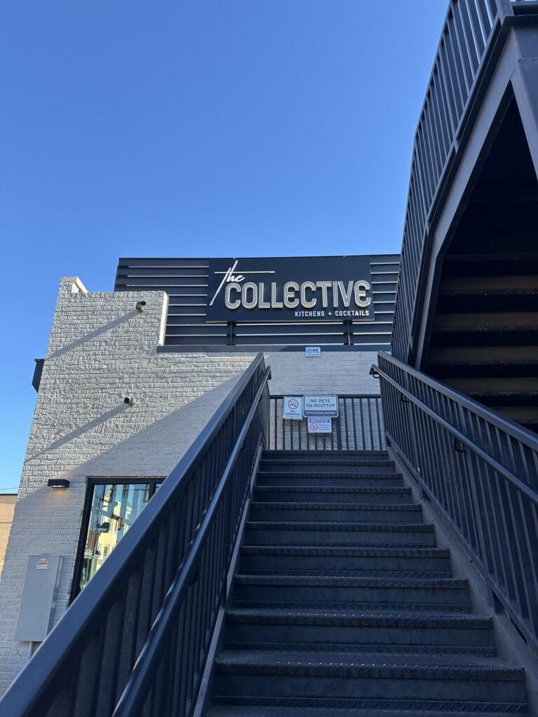 Exterior stairs and sign for The Collective Kitchens and Cocktails in Oklahoma City.