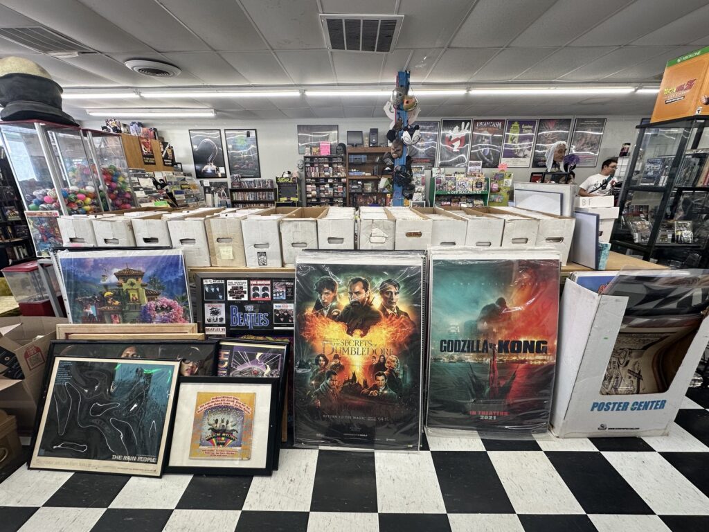 Wide interior view of Geeks Garage in Moore with comic boxes, framed posters, poster bins, display cases, and collectibles.