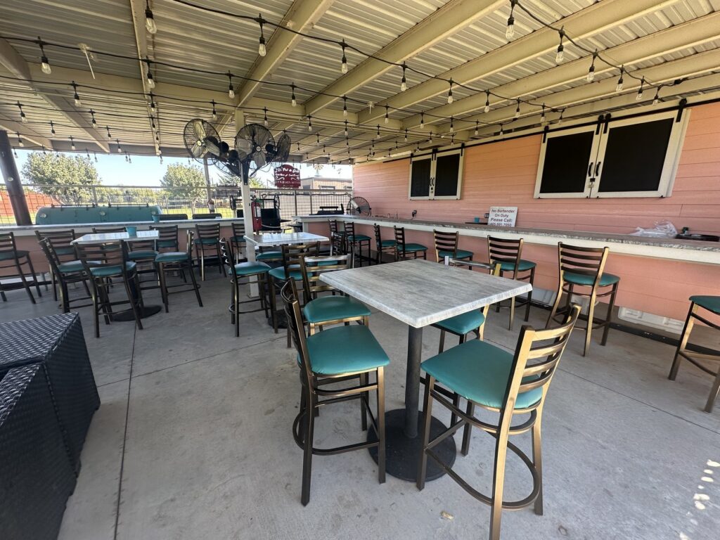 Covered patio seating area with high-top tables and string lights at JR’s Pub and Grill in Oklahoma City.
