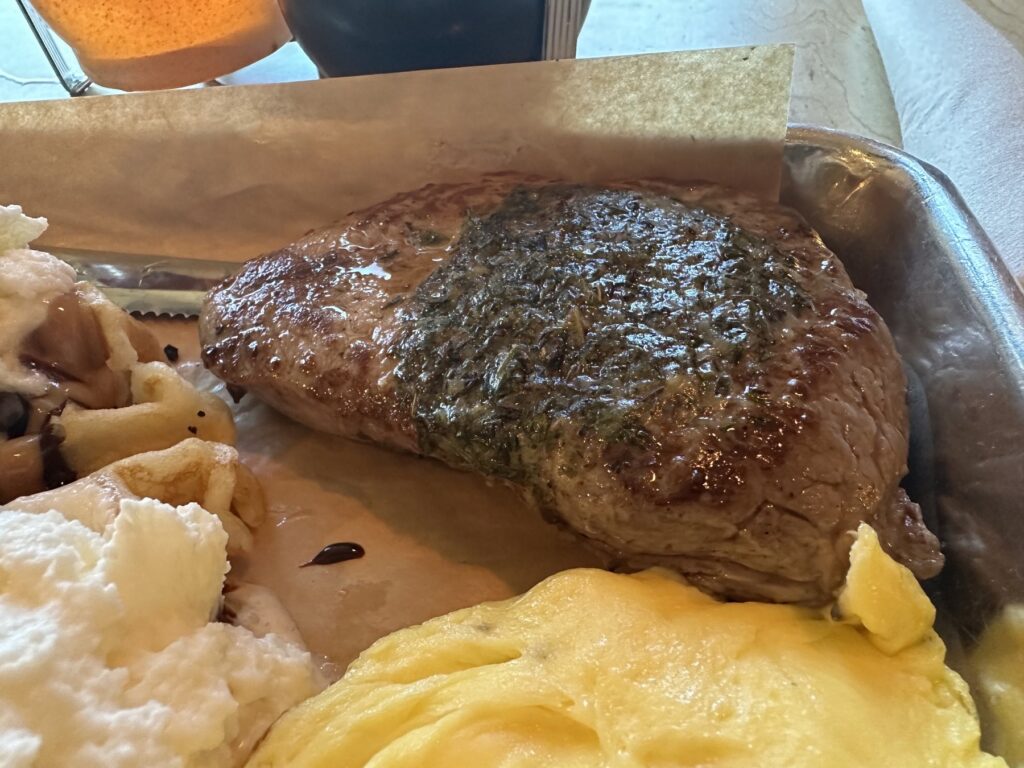 Close-up of steak with eggs and waffle on a tray at Just Wafflin’ in Stillwater
