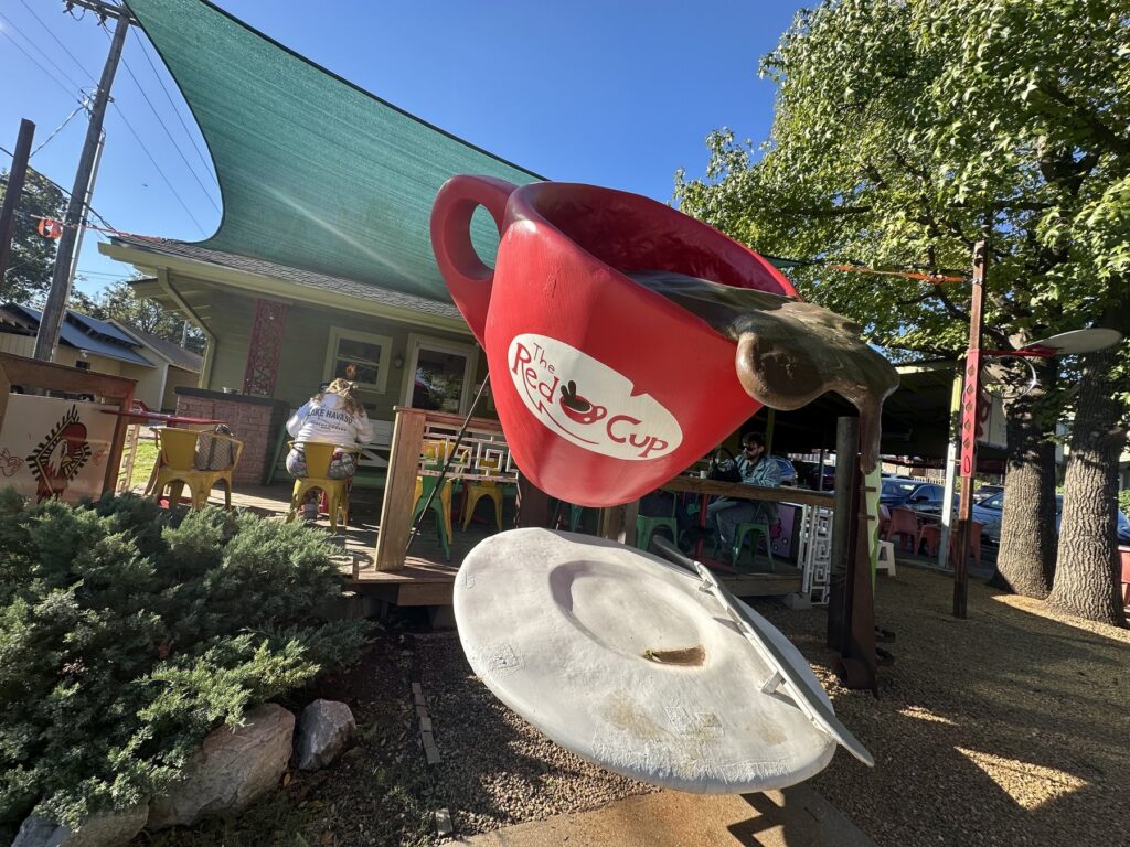 Giant red cup sculpture pouring coffee outside The Red Cup in Oklahoma City.