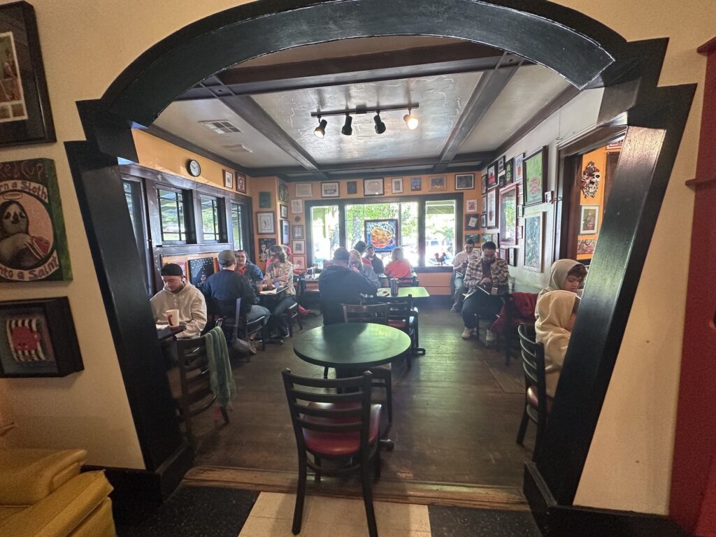Busy art-filled dining room inside The Red Cup vegetarian cafe in OKC.