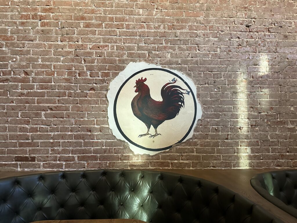Rooster mural on an exposed brick wall inside Red Rooster in Oklahoma City.