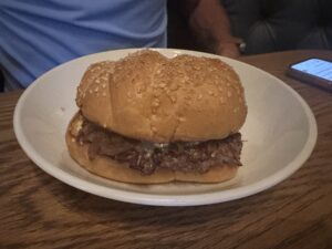 Burger with melted cheese and onions on a sesame bun at Red Rooster in Oklahoma City.