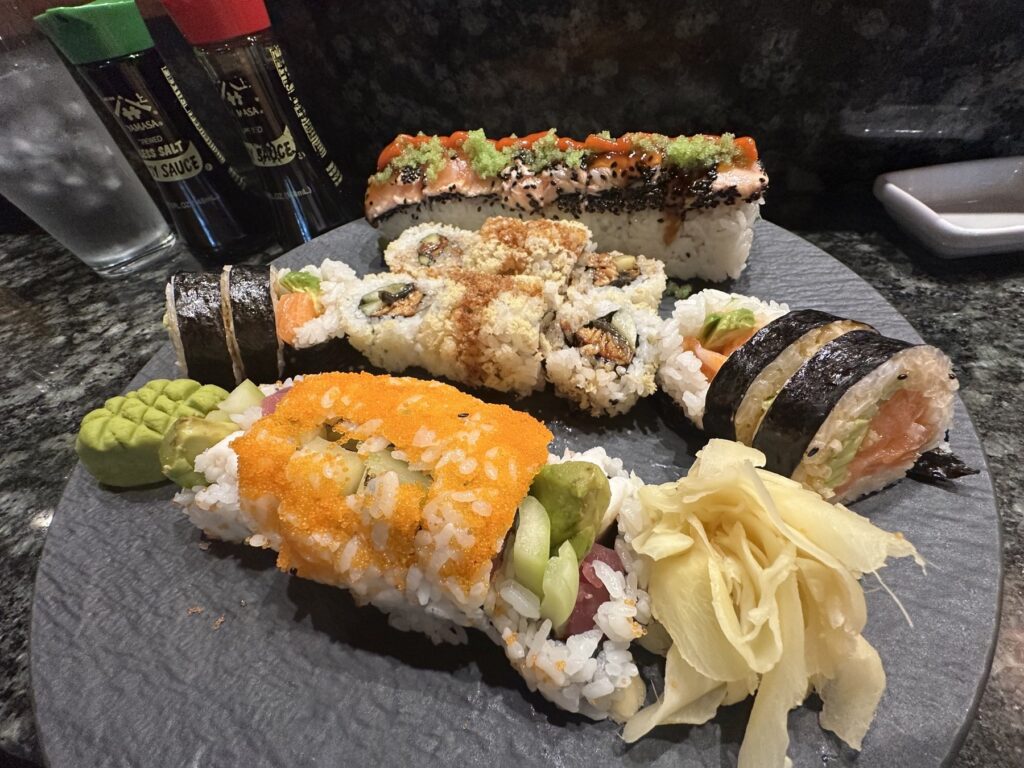 Plate of assorted Sushi Neko rolls with wasabi and pickled ginger.